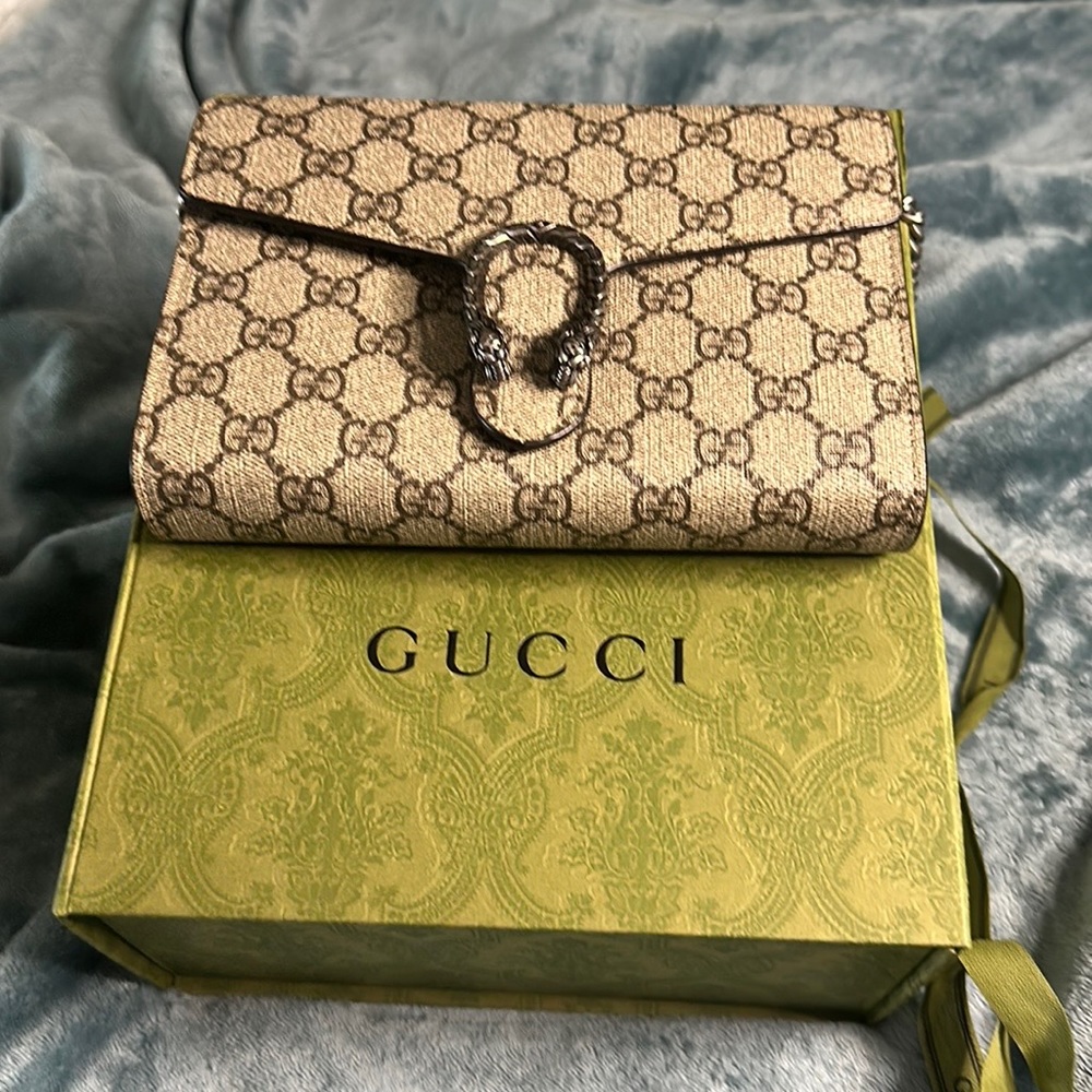 GUCCI GG Supreme canvas wallet on chain with textured tiger head spur closure.